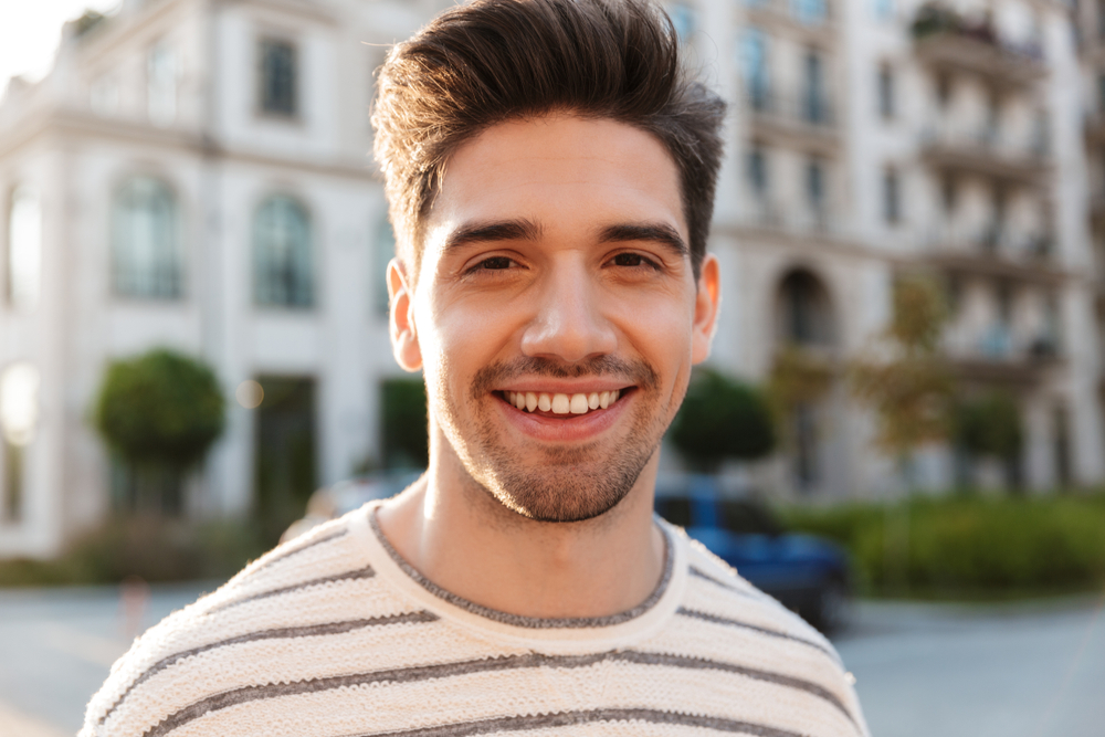 Handsome man taking a photo outdoors - Smile Makeover in Orlando
